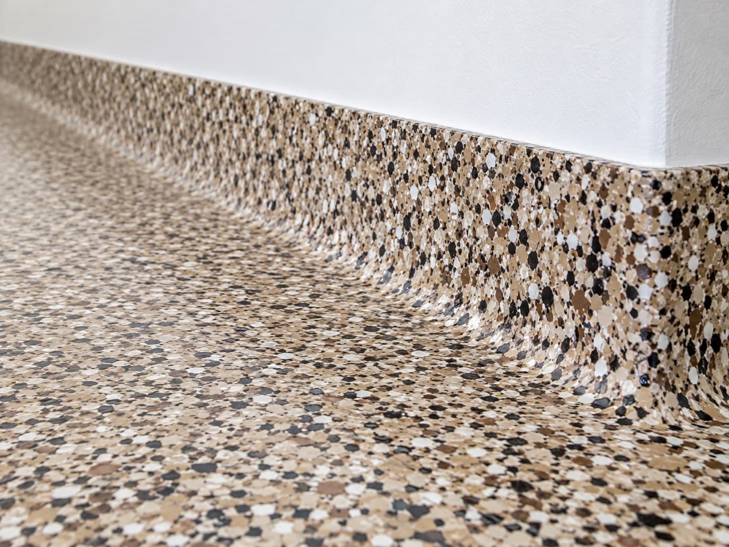 Floor coating curving seamlessly up the wall